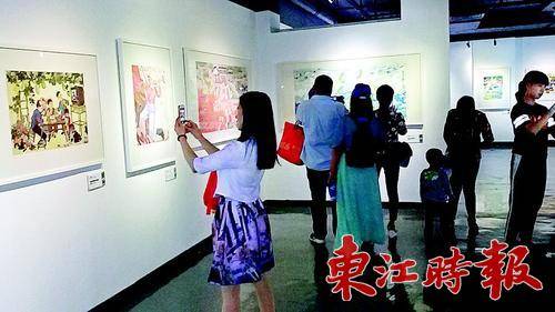 游客们在欣赏农民画。
