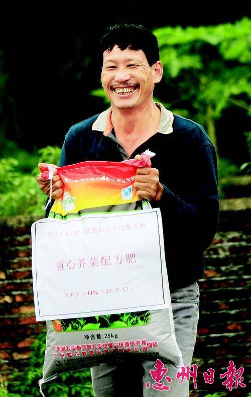  拿到农技人员送来的专用肥，连扬平满脸笑容。
 本报记者魏云鹤 摄
