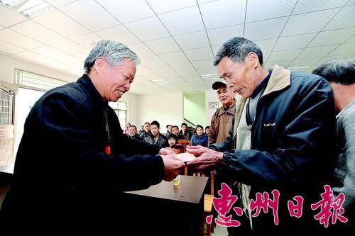  惠州报业传媒集团离退休党员代表（左）给石莲村老党员送上慰问金。 本报记者钟畅新 摄 