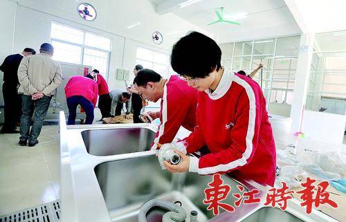 志愿者在帮忙安装厨具。 《东江时报》记者张艺明 摄
