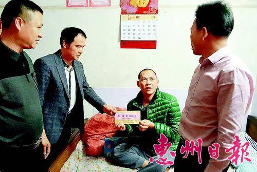  驻村干部与镇村干部一同到廖根本家慰问，并送上救助金。文/图 本报记者黄宇翔
