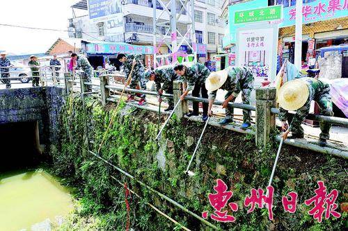  ▲民兵预备役人员在县城环城北路的河道旁清淤。 