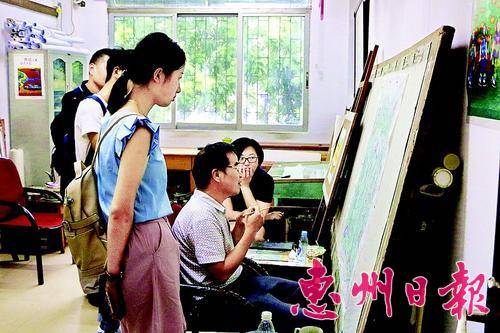 媒体记者看龙门农民画画家创作。
