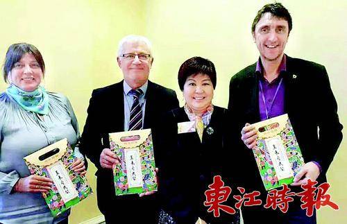  英国华民社罗村娥女士(左三)将中国特色龙门农民画丝巾赠送给英国的朋友。 